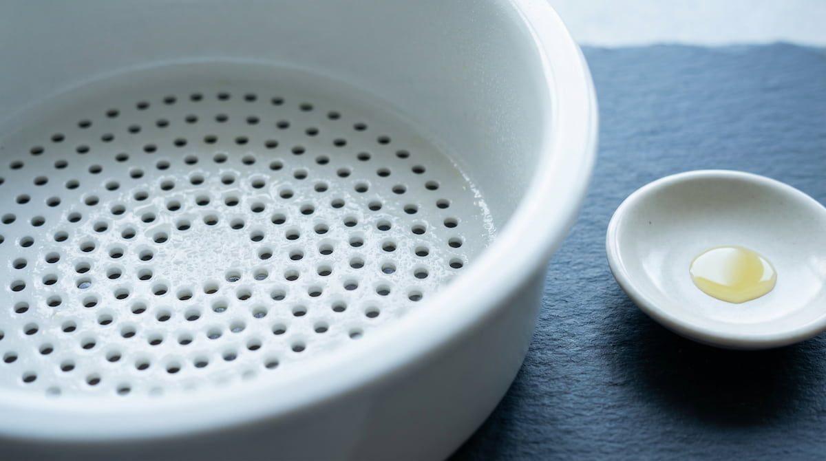 Close-up of clean ceramic air fryer basket with light oil spray — PFAS-free surface for healthier everyday cooking