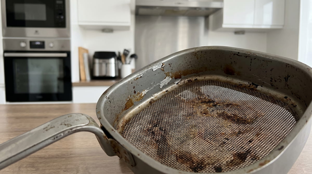 Damaged PTFE air fryer basket with rough discolored coating