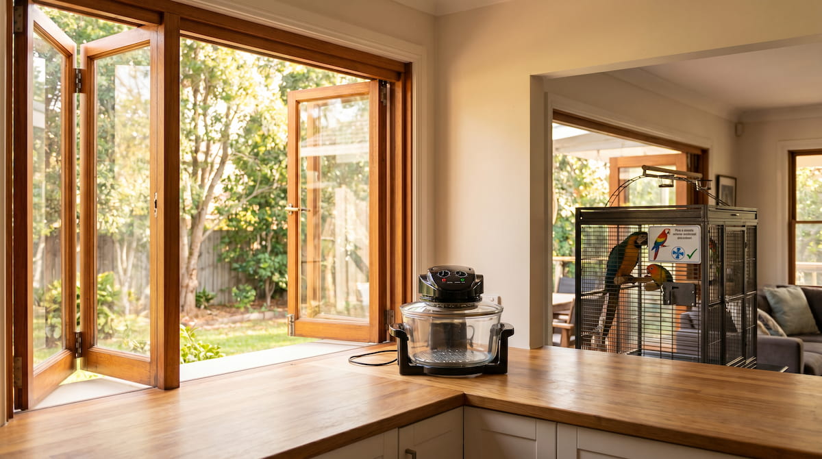 open kitchen glass air fryer with parrot cage in background bird safe setup