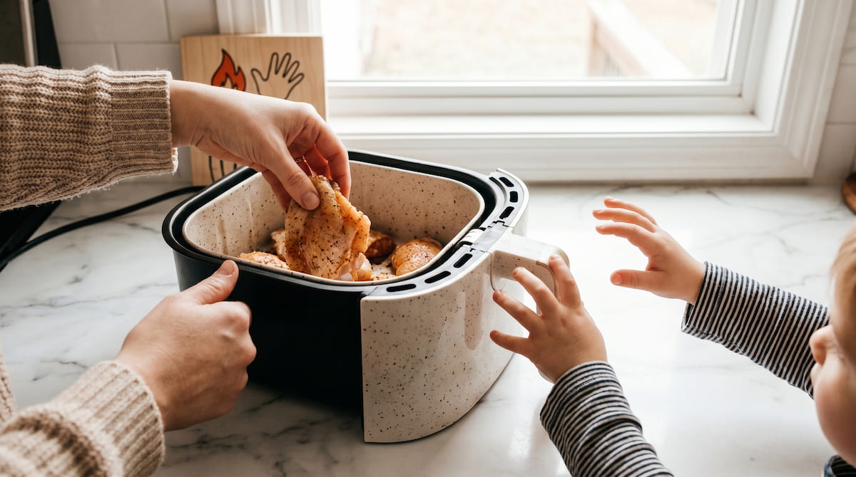 parent and child hands near ceramic air fryer safe family cooking kitchen